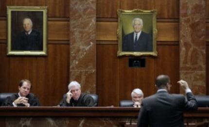  Texas Supreme Court justices, from left, Don Willett, Paul Green, and Nathan Hecht listen...