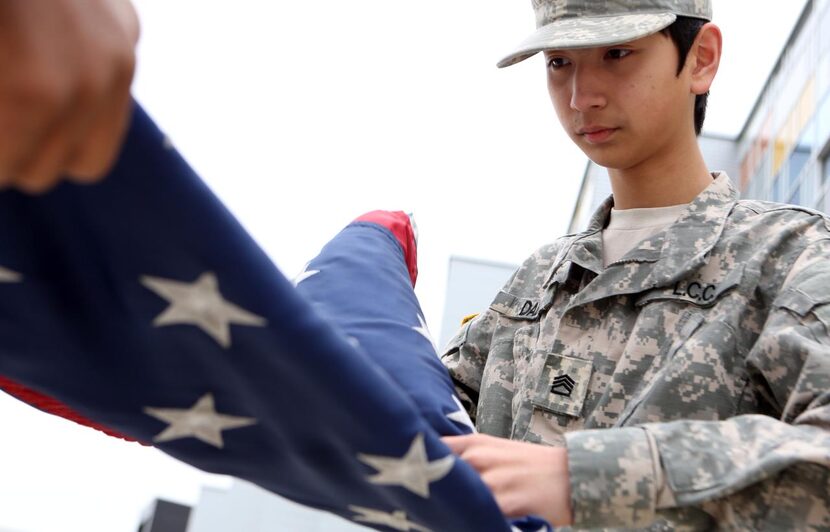 
Kim Manrique folds the U.S. flag after lowering it at the end of the school day.
