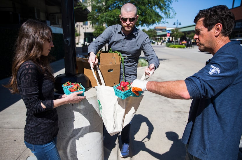 Farmer John Kilburn (right) of Comeback Creek Farm drops off a box of fruits and vegetables...