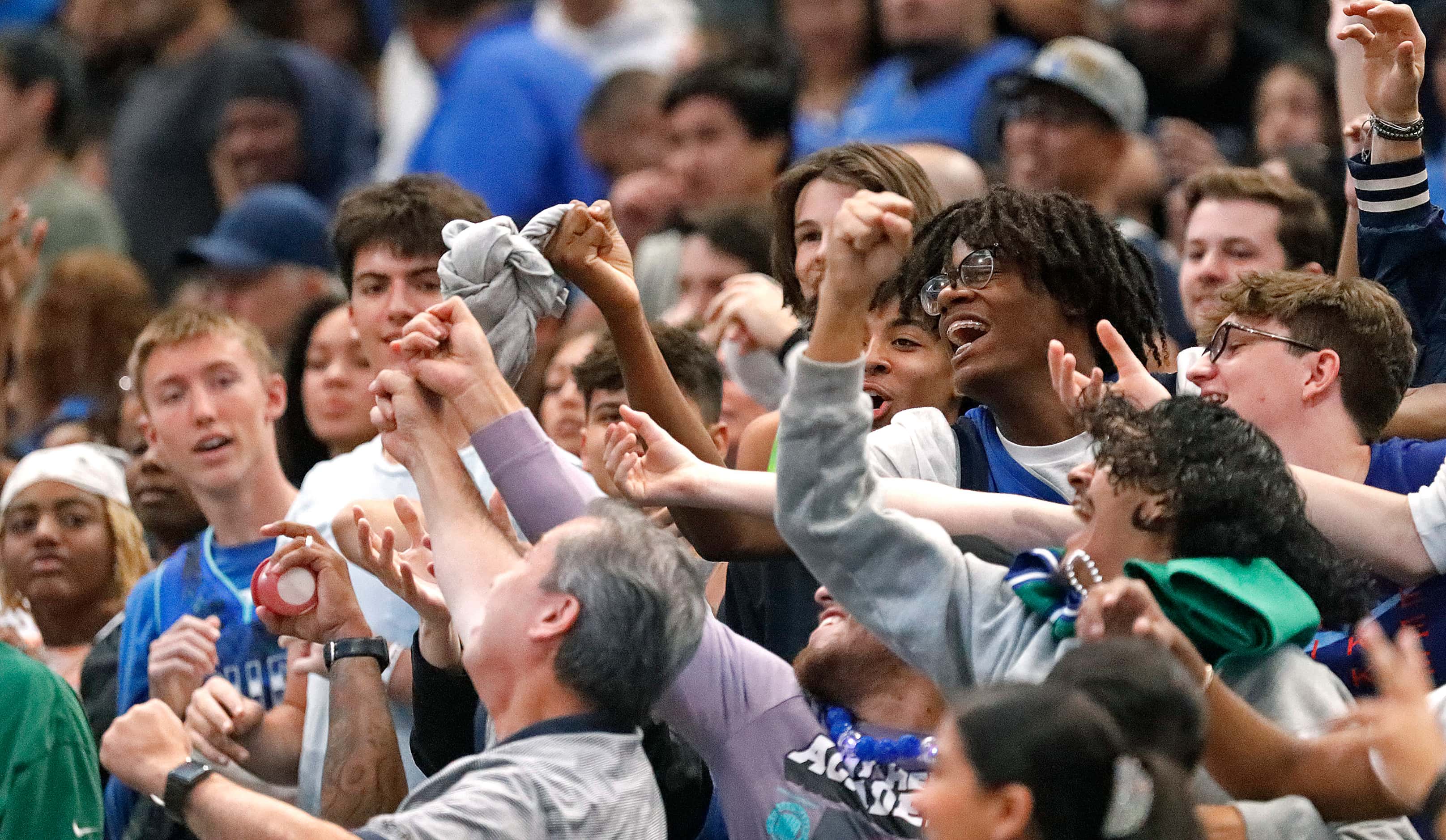 Fans vie for a promotional t-shirt at the Mavs Fan Jam, a free scrimmage for the fans held...