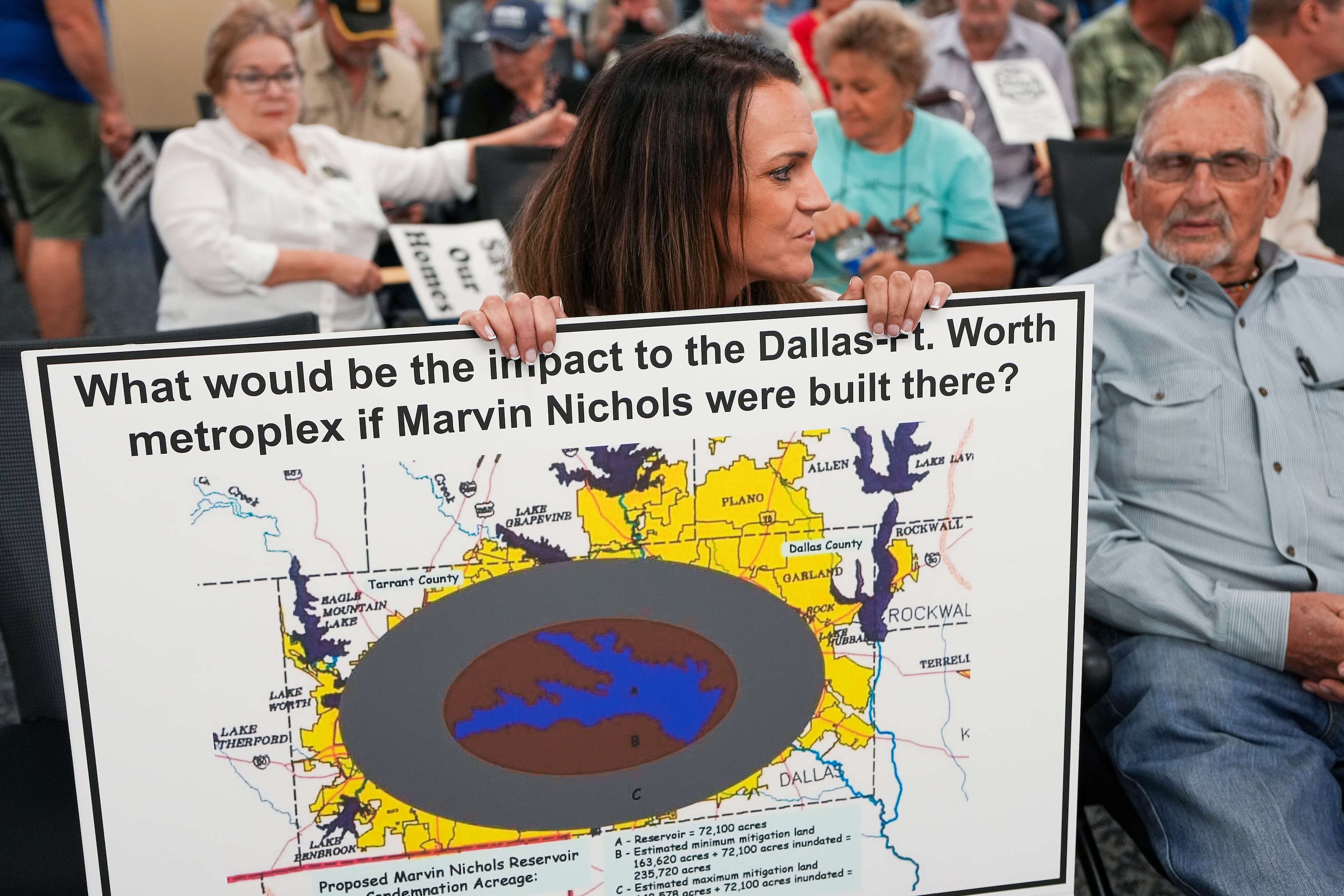 Brooke Ward holds a poster with an image of what the footprint of the proposed Marvin...