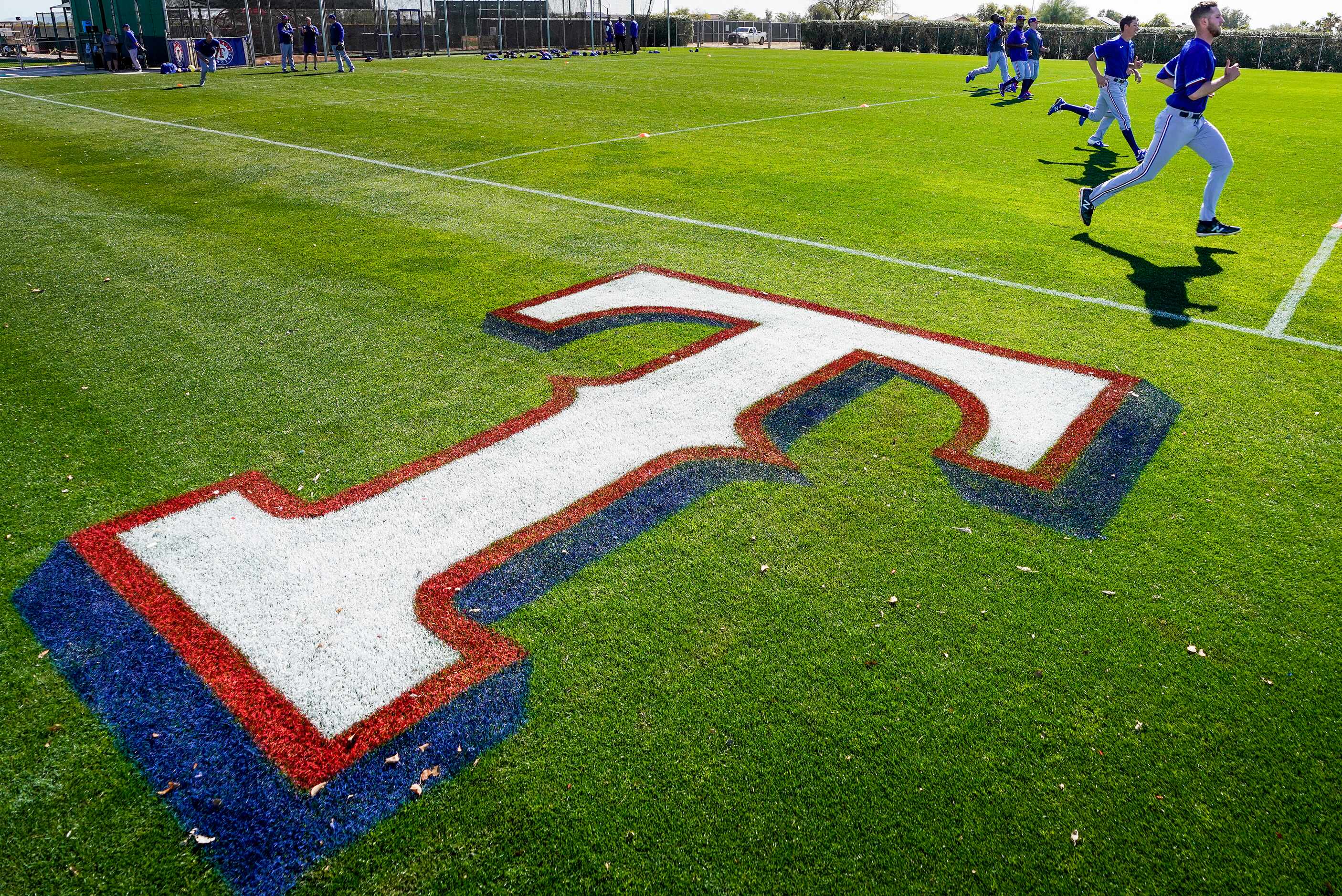 Texas Rangers pitchers run on a conditioning field during a spring training workout at the...