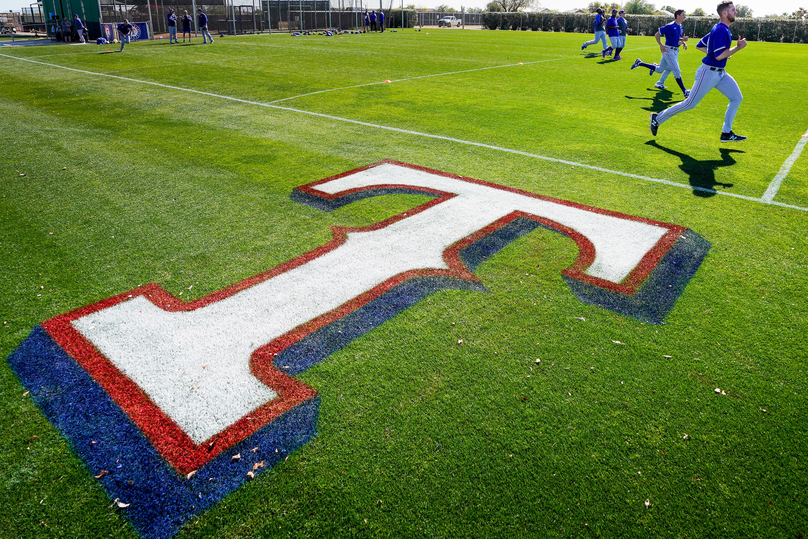 Texas Rangers pitchers run on a conditioning field during a spring training workout at the...