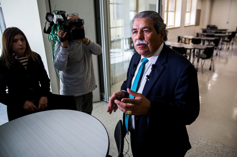 Dallas ISD Superintendent Michael Hinojosa (right) talks about classroom space to reporters...