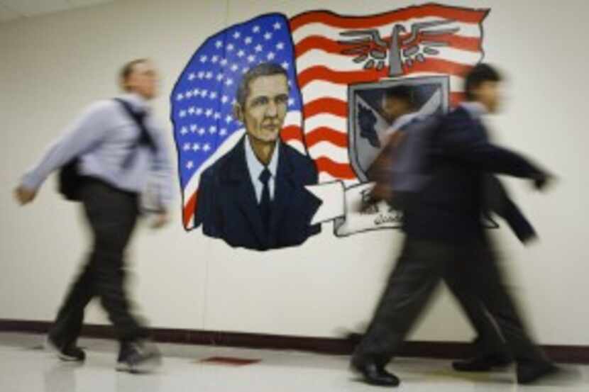  Students walk past a mural of President Barack Obama painted by art teacher Dane Larsen and...