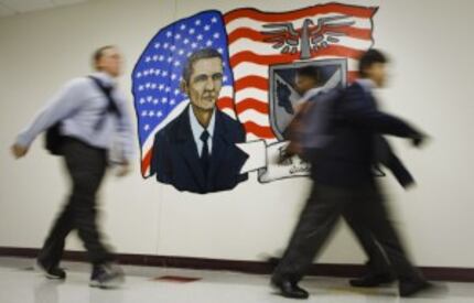  Students walk past a mural of President Obama painted by art teacher Dane Larsen and the...