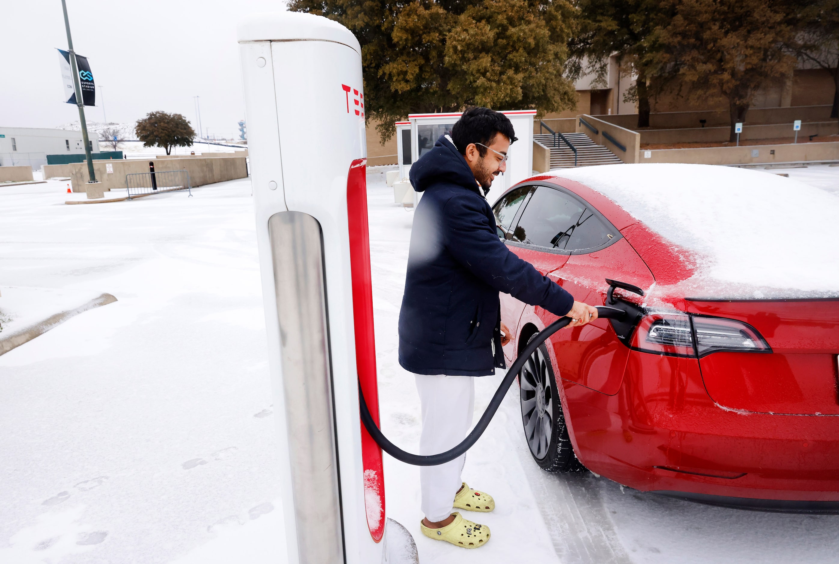 Ritesh Kumar of Arlington charges his Tesla Model 3 outside Esports Stadium Arlington after...