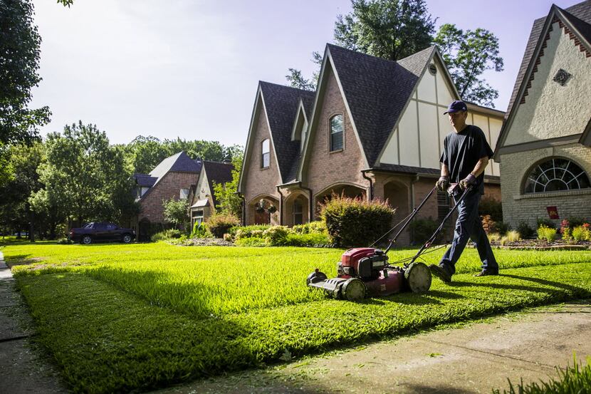 Joel McCloskey cuts the grass of a house in the M Streets in Dallas. McCloskey  works with...
