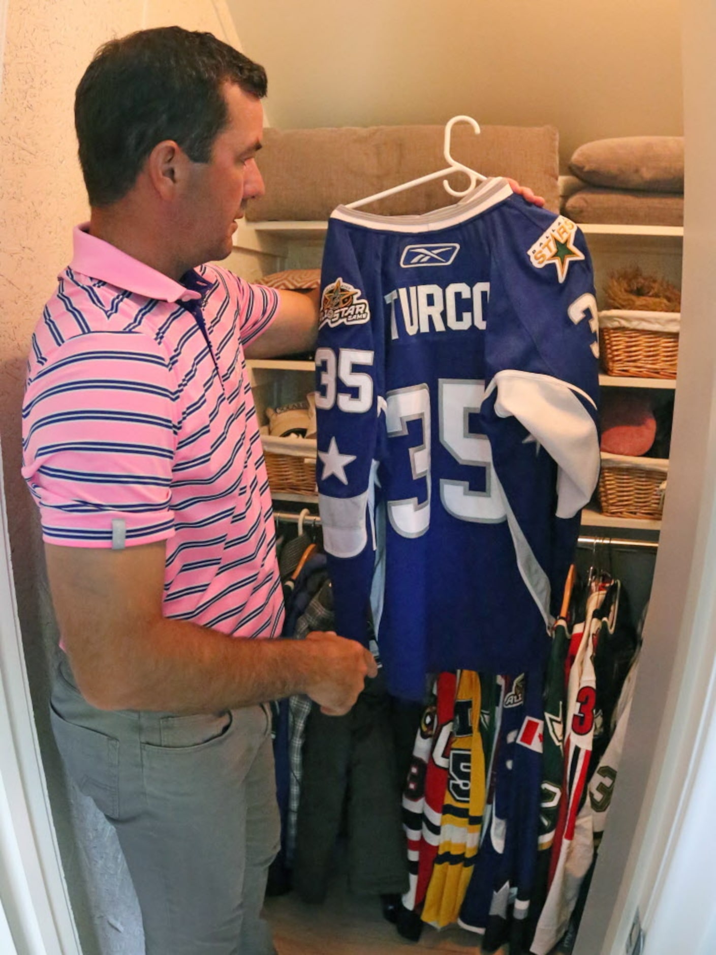 Former Dallas Stars goalie Marty Turco shows his jersey from the 2007 NHL All-Star Game that...