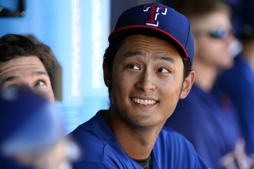 Mar 10, 2014; Surprise, AZ, USA; Texas Rangers pitcher Yu Darvish (11) in the dugout after...