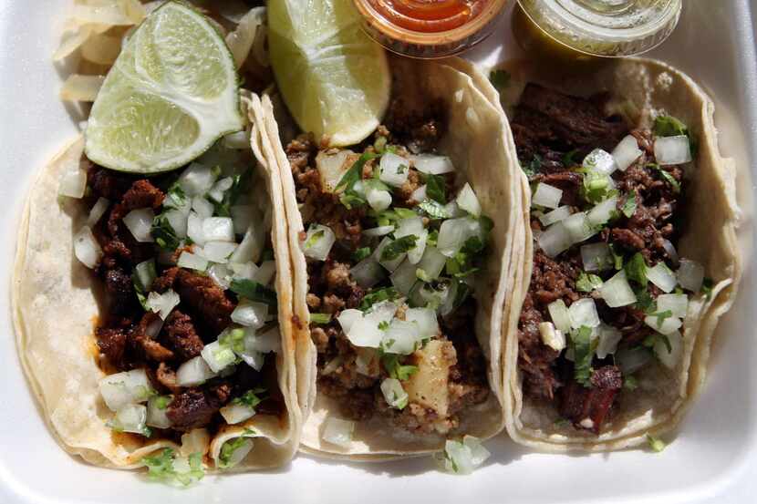 A plate of al pastor, left, picadillo and barbacoa corn tacos from Fuel City, on Nov. 17,...
