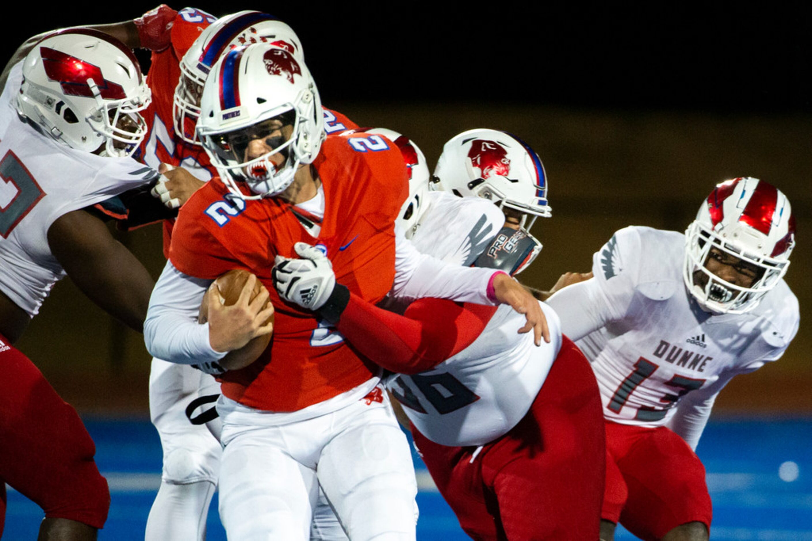 Parish Episcopal quarterback Preston Stone (2) gets taken down by Bishop Dunne defensive...