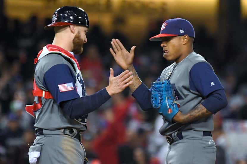 U.S. catcher Jonathan Lucroy, left, greets pitcher Marcus Stroman in the sixth inning...