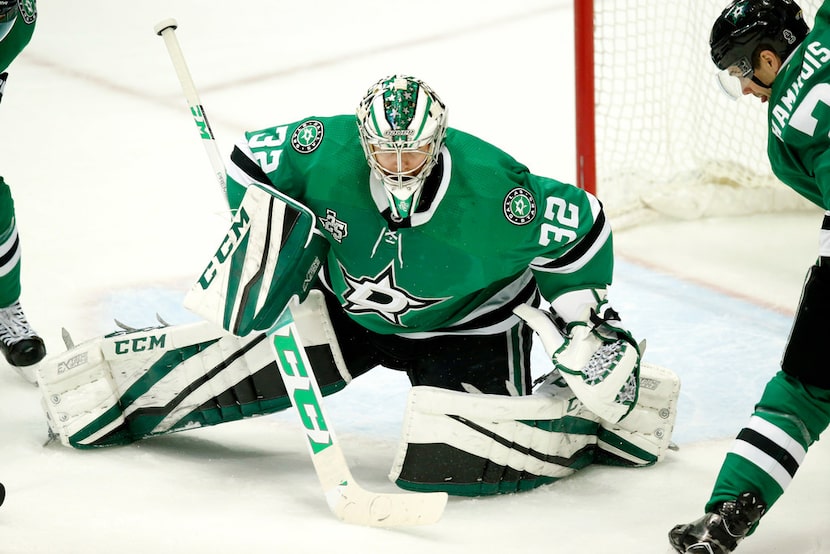 Dallas Stars goaltender Kari Lehtonen (32) covers a shot on goal by Minnesota Wild during...