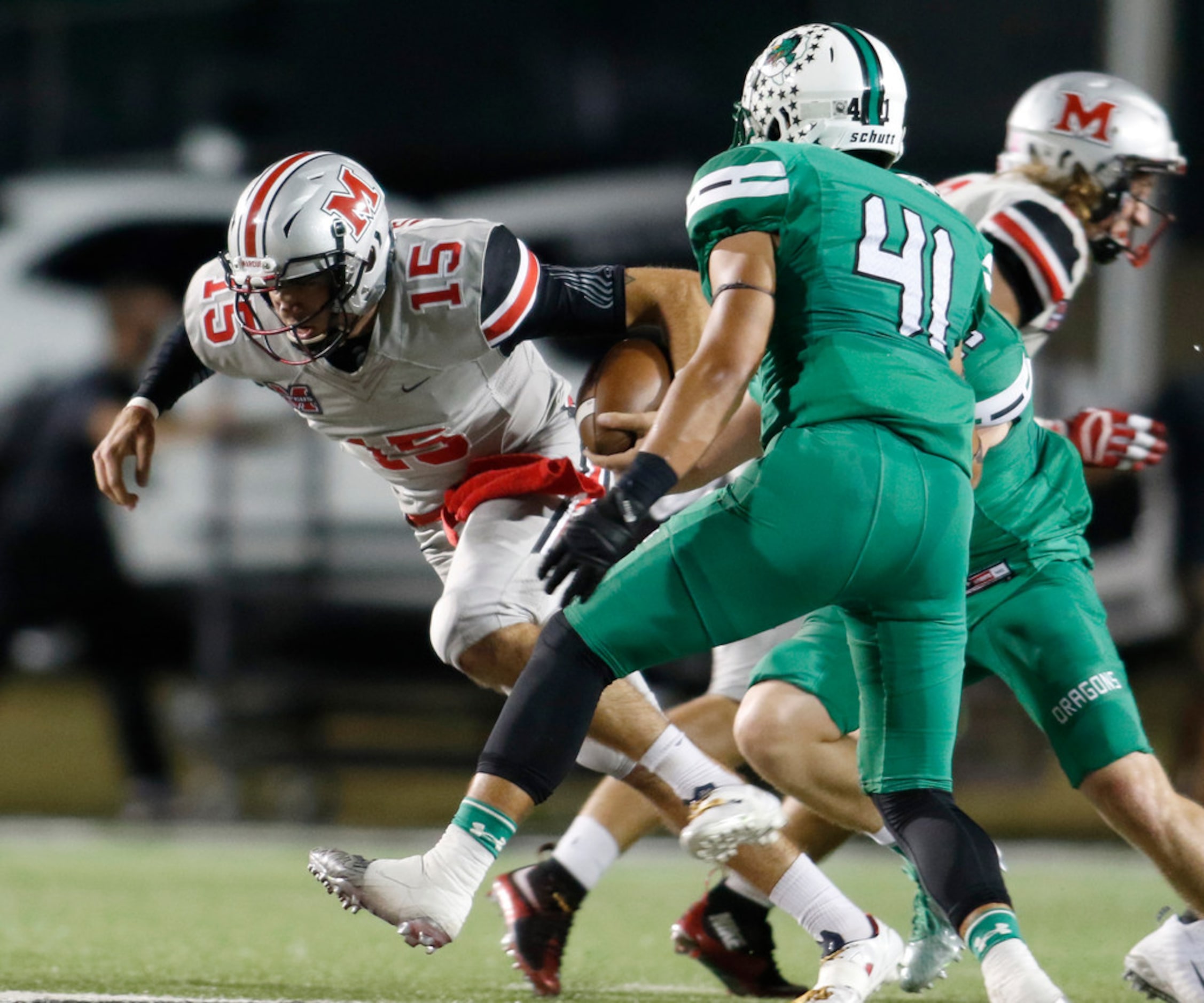 Flower Mound Marcus quarterback Xavier Maxwell (15) lunges for extra yardage after being hit...