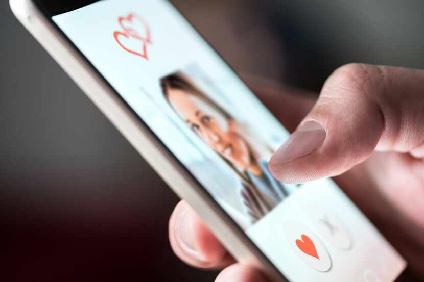 Un hombre utiliza una app en su teléfono para buscar pareja.