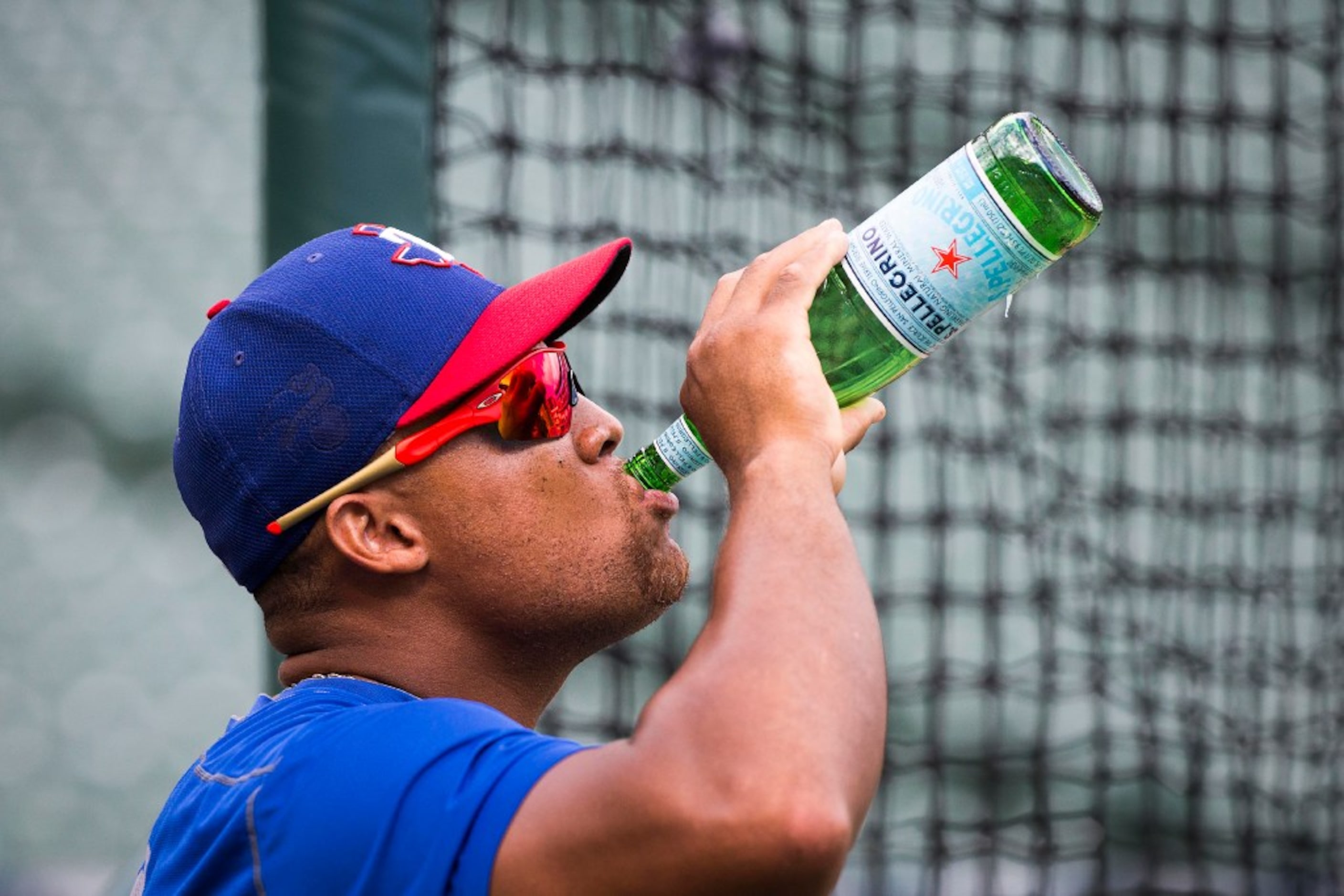 Texas Rangers third baseman Adrian Beltre drinks a bottle of mineral water during the team...