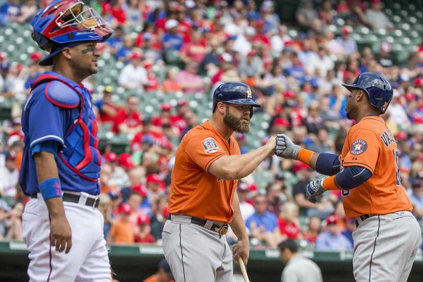 Houston Astros third baseman Luis Valbuena (18) is congratulated by designated hitter Evan...