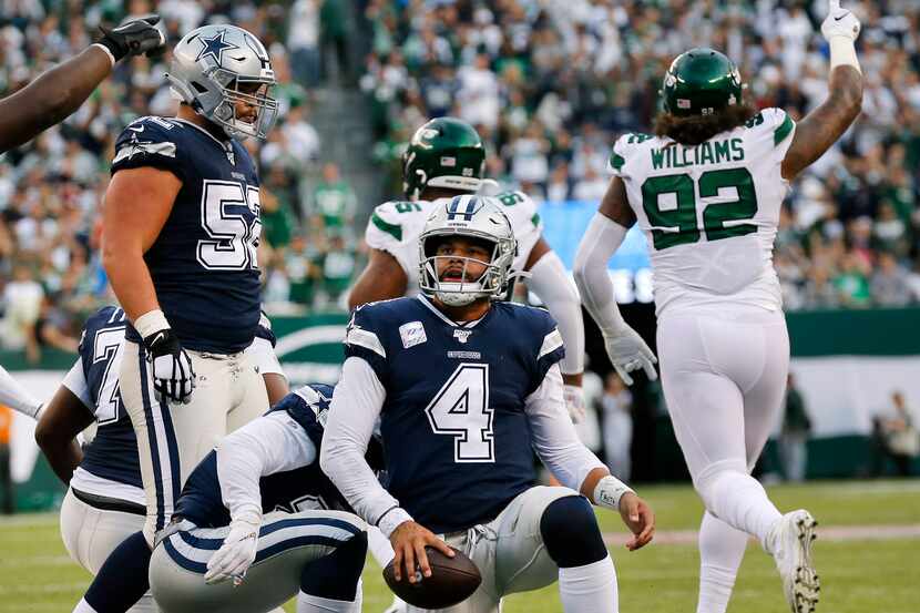 Dallas Cowboys quarterback Dak Prescott (4) gets back to his feet after being stopped short...