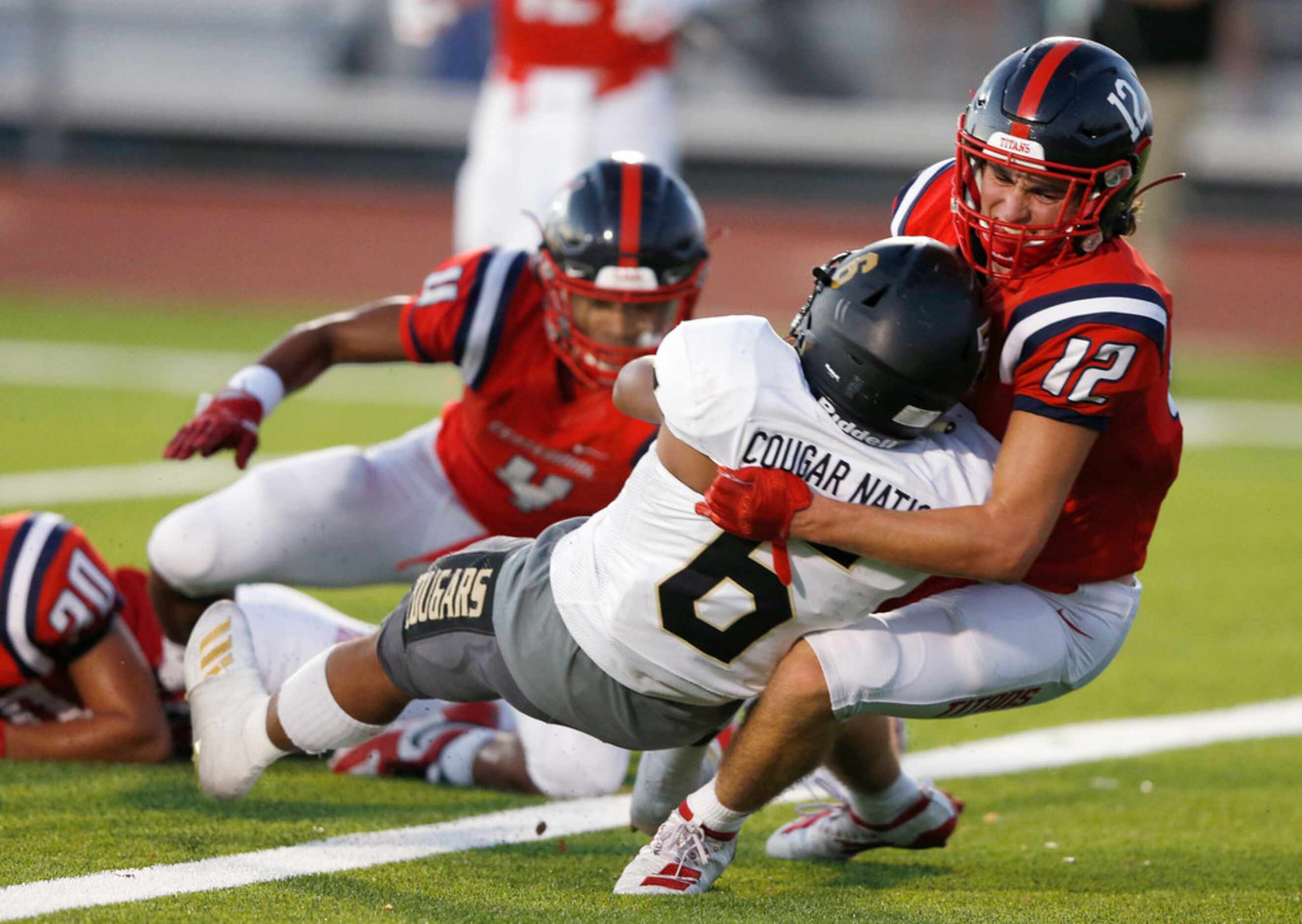 The Colony's Kamden Wesley (6) scores a touchdown as he is brought down by  Centennial's...