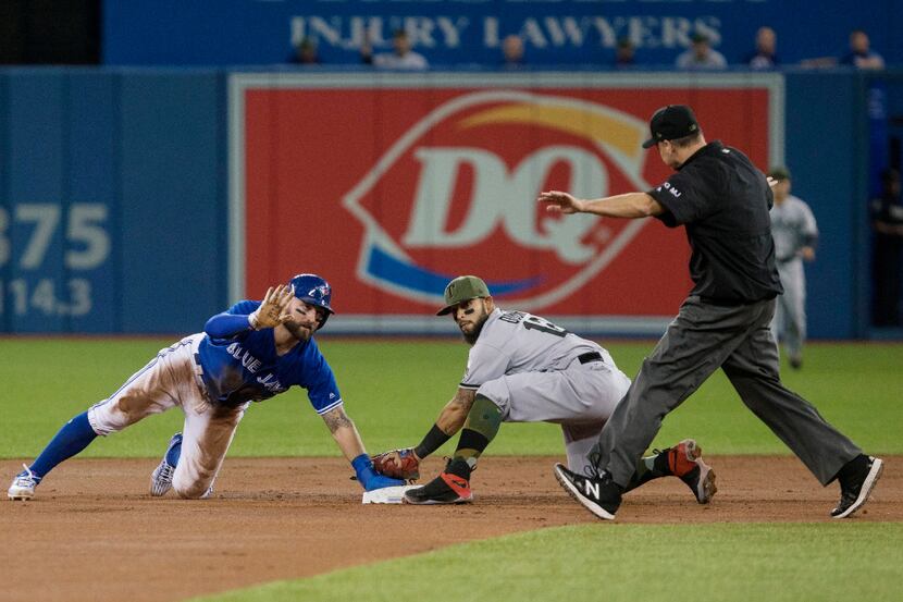 Toronto Blue Jays' Kevin Pillar, left, is called safe by umpire Andy Fletcher, right, after...