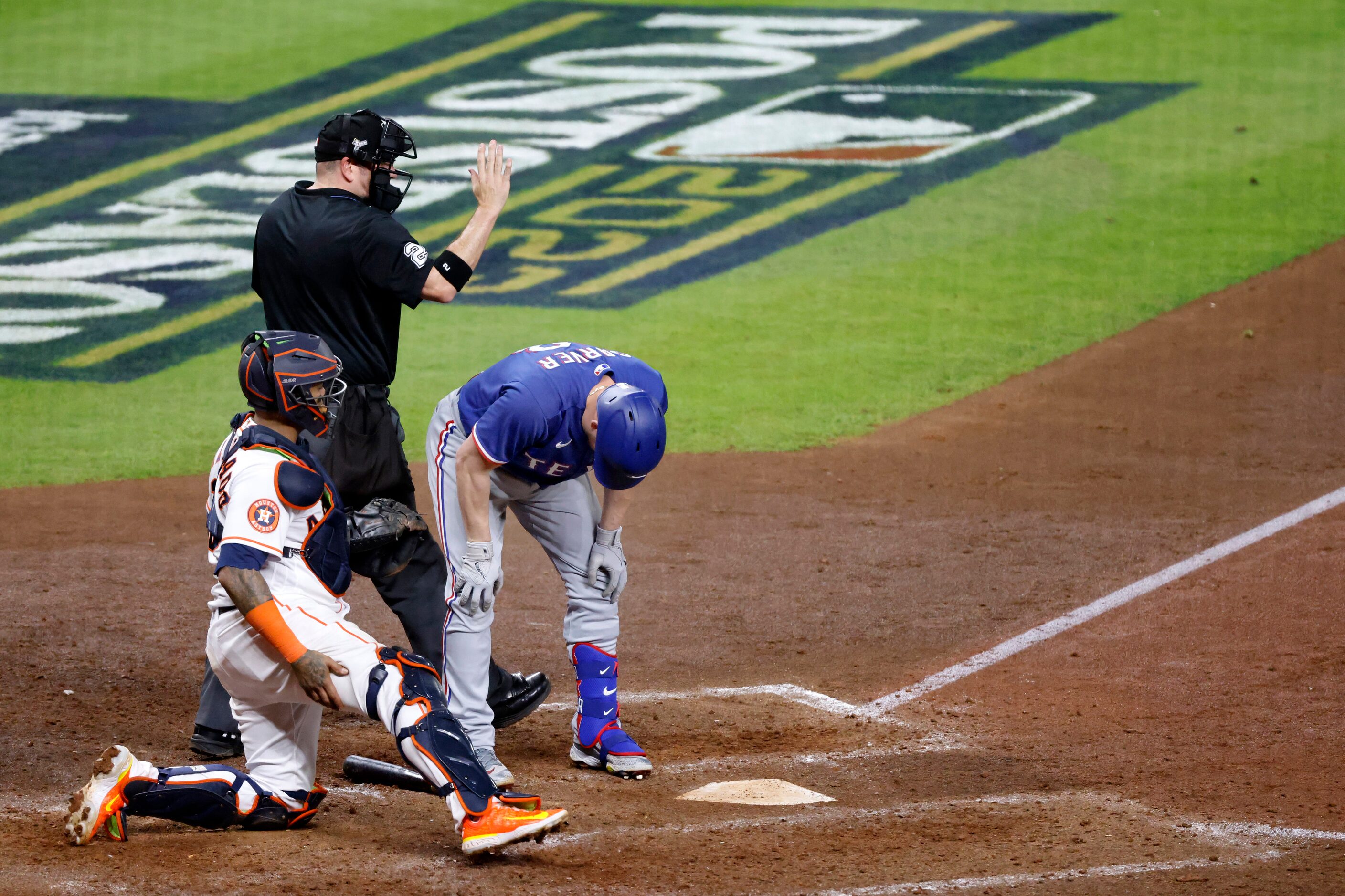 Home plate umpire Dan Bellino calls time after Texas Rangers batter Mitch Garver (18) bends...