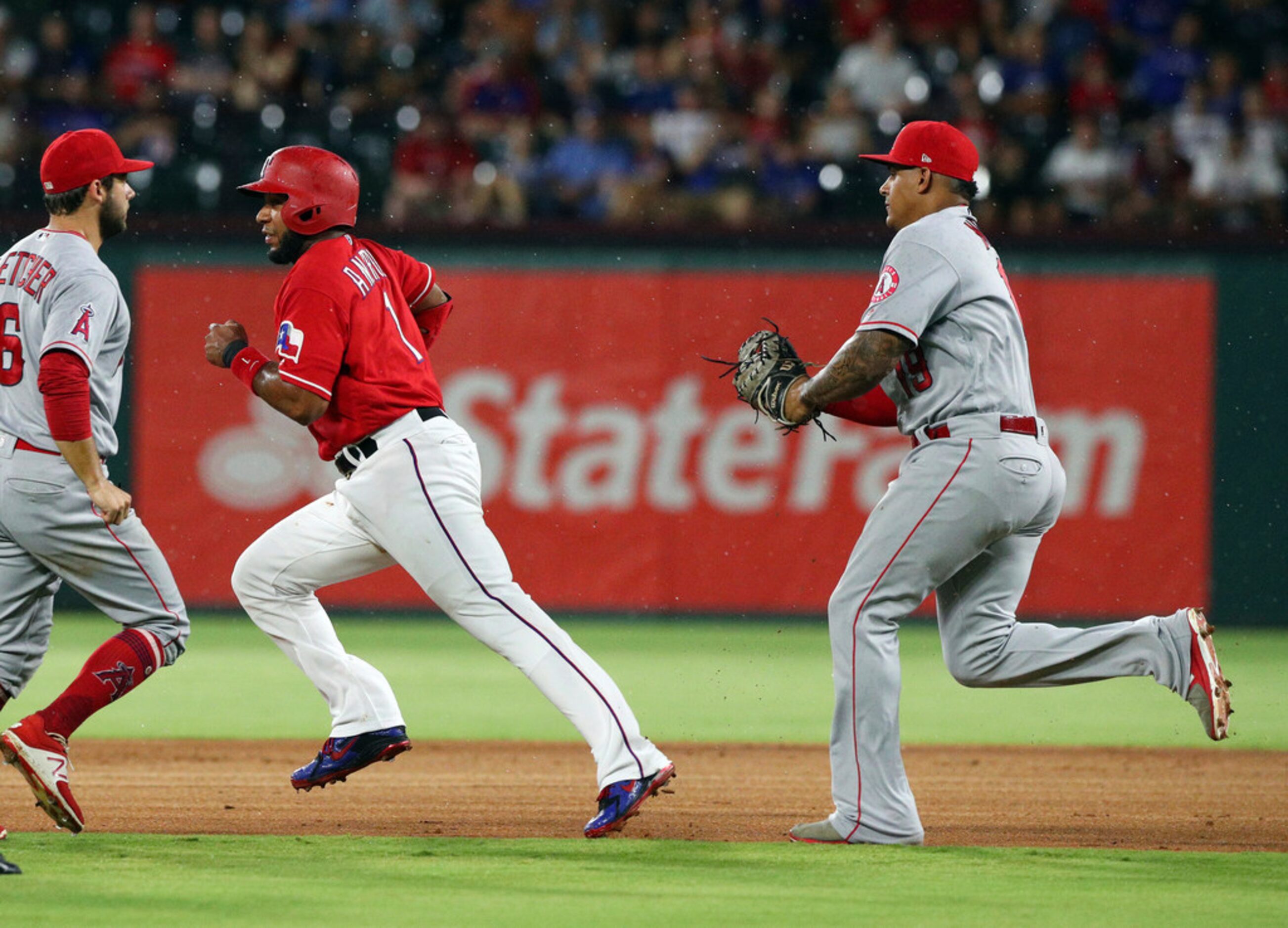 Texas Rangers' Nomar Mazara, left, greets Rougned Odor (12) who scored during the first...