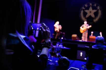 A patron records singer Shawn Mullins on her smartphone as he took the stage in concert at...
