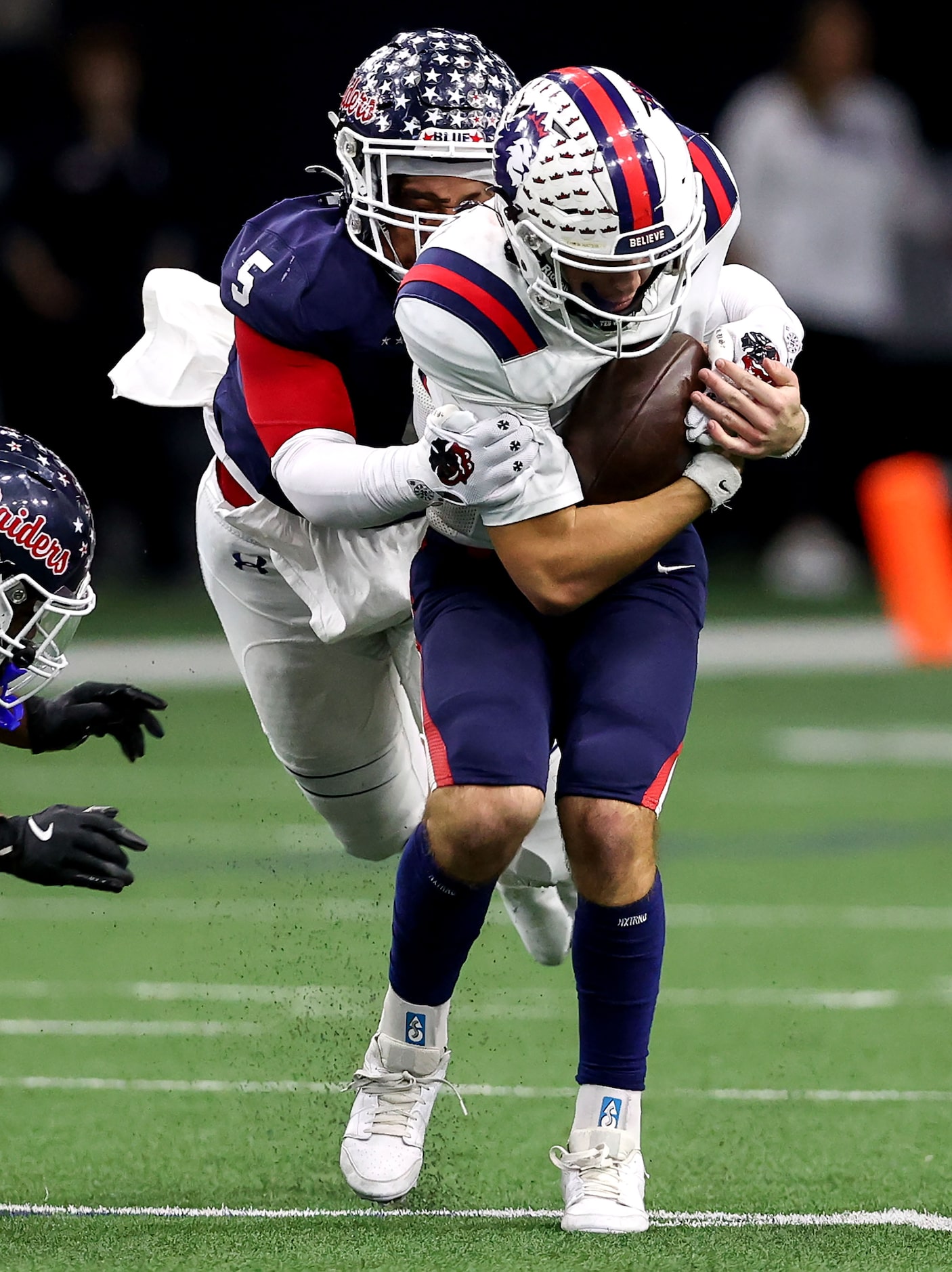 Richland quarterback Drew Kates tries to scramble past Denton Ryan defensive lineman Uzziah...