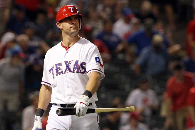 Texas Rangers designated hitter Michael Young follows through on a bases clearing double in...