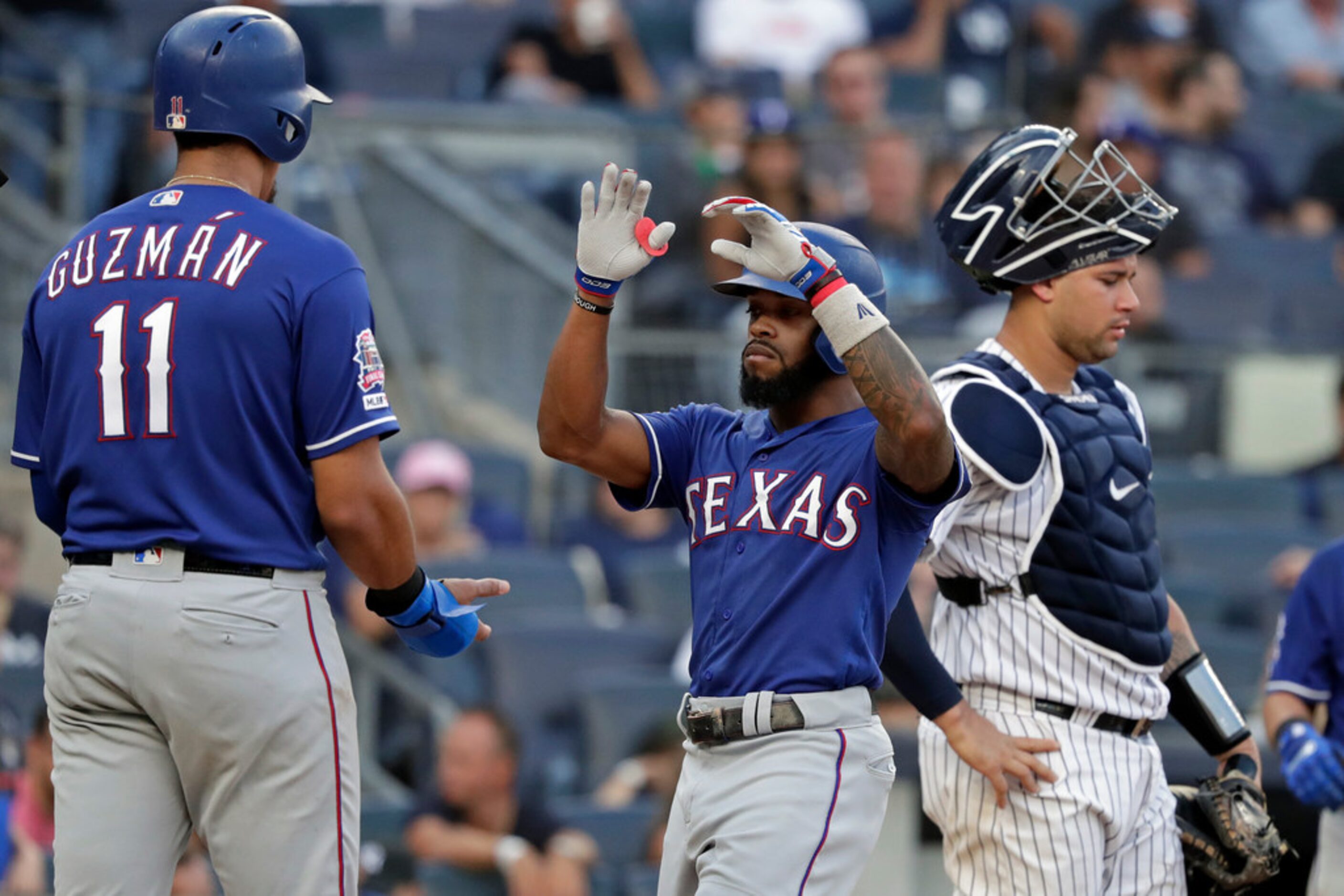 Texas Rangers' Delino DeShields celebrates hitting a three-run home run with teammate Ronald...