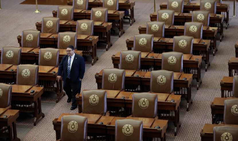 Texas House of Representatives Sergeant-at-Arms David Sauceda walks through an empty chamber...