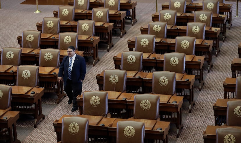 Texas House of Representatives Sergeant-at-Arms David Sauceda walks through an empty chamber...