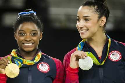 Simone Biles and Aly Raisman of the United States show off their gold and silver medals...
