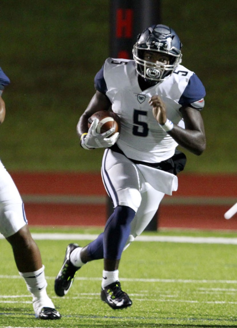 Wylie East quarterback Eno Benjamin (5) looks for an opening during the first half of a high...