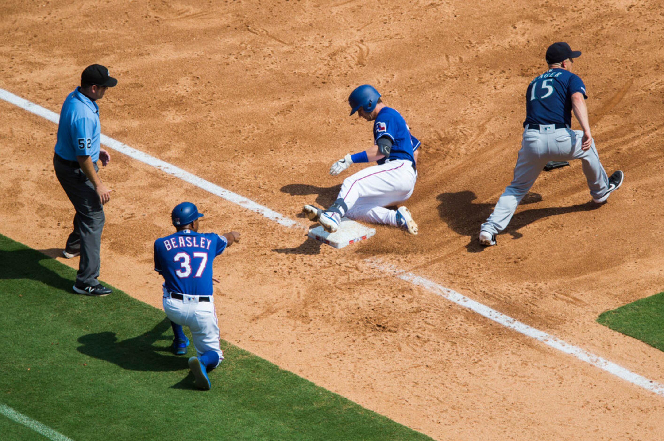 Texas Rangers designated hitter Nick Solak (15) slides in to third base ahead of Seattle...