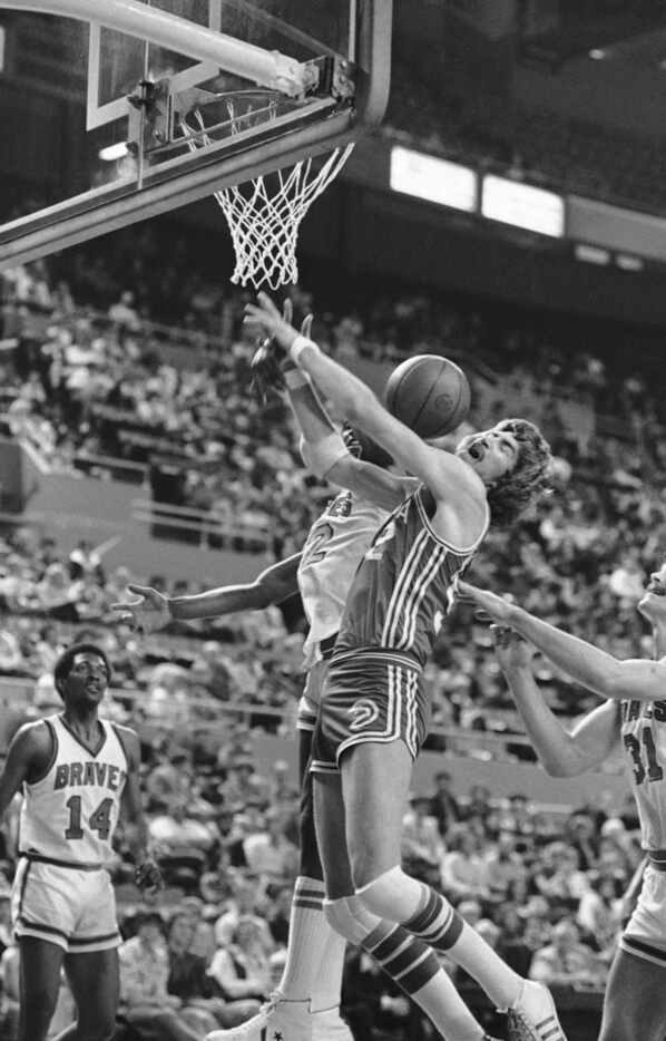 Buffalo Braves Bill Willoughby knocked the ball away from the Atlanta Hawks' Tom McMillen...
