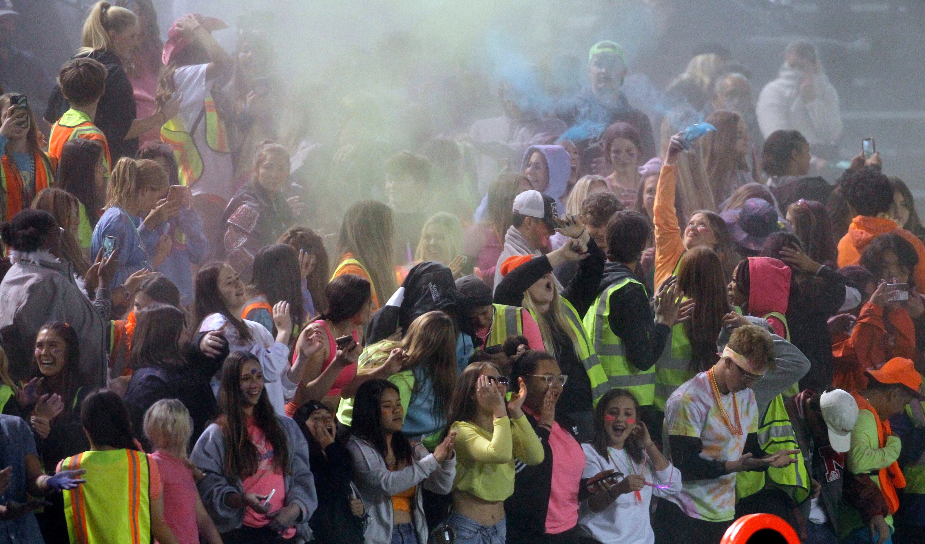 Arlington Martin fans filling the student section are showered with baby powder emitted into...