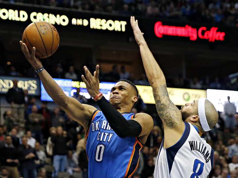 Oklahoma City Thunder guard Russell Westbrook (0) gets past Dallas Mavericks guard Deron...