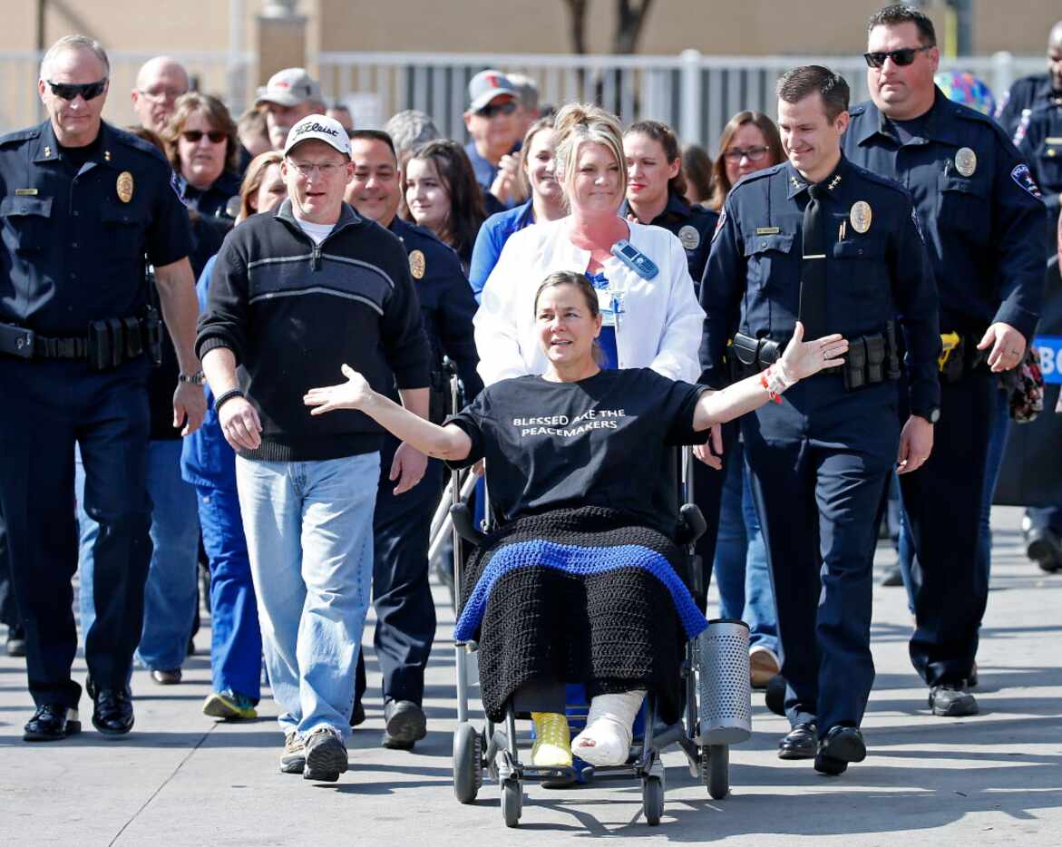 Arlington police officer Cpl. Elise Bowden (in a wheelchair) waves to the crowd as she is...