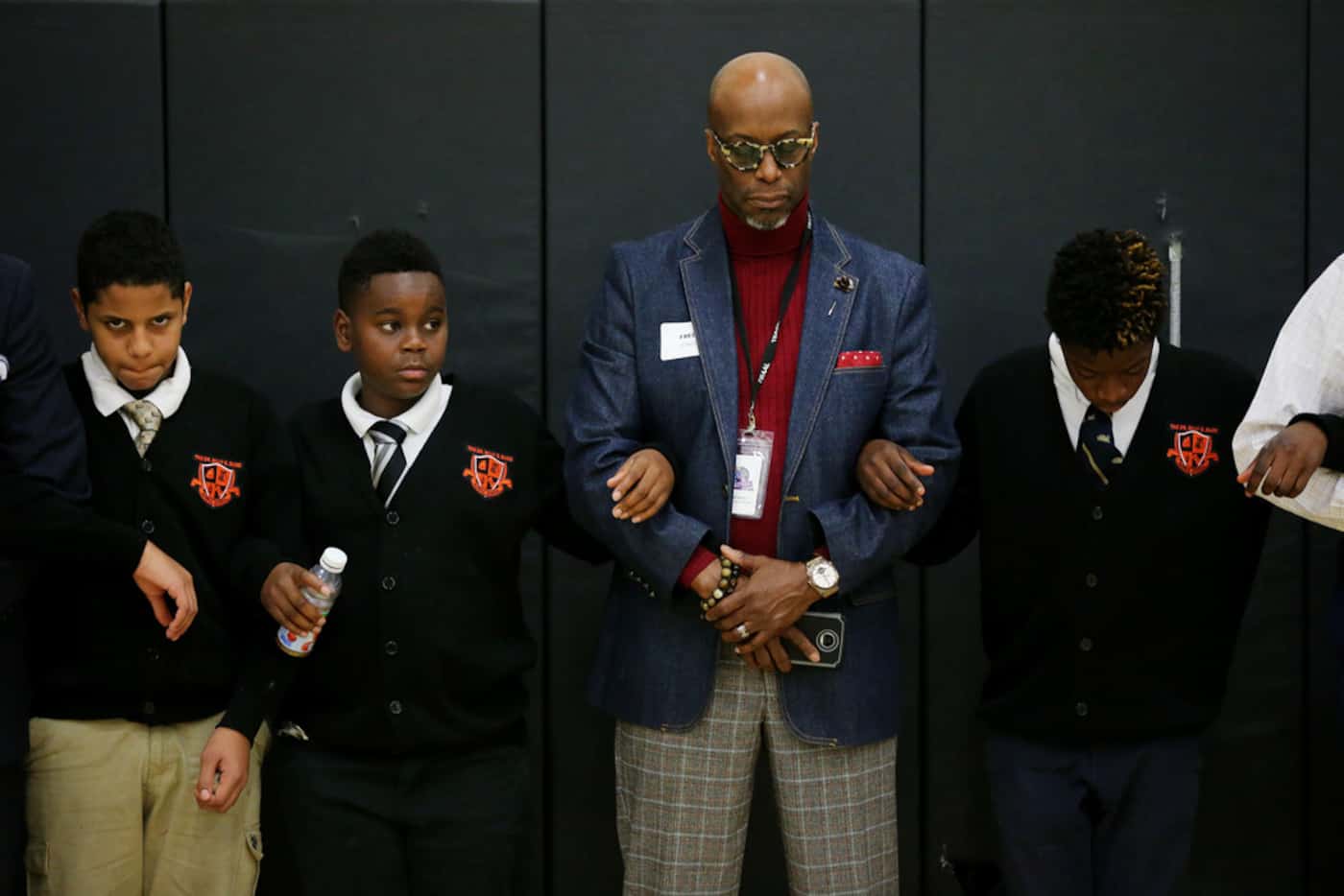 Students and mentors locked arms during a prayer at the end of the "Breakfast with Dads"...