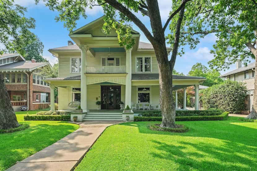 Historic home with grand porch, verdant lawn and large tree