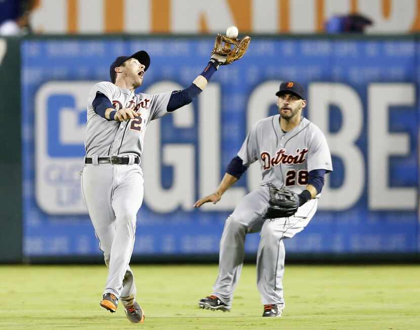 Detroit Tigers third baseman Andrew Romine (27) catches a fly ball hit by Texas Rangers...