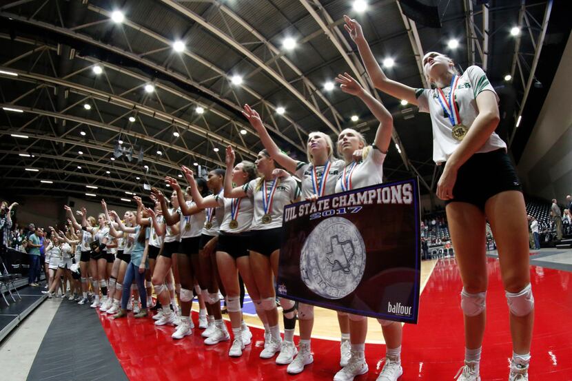 Members of the state Class 5A volleyball champion Prosper Eagles pause for the playing of...