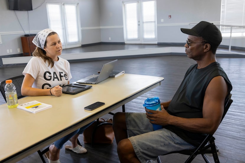 Evelyn Mayo (left) asks resident Larry Page public health survey questions at a Singleton...