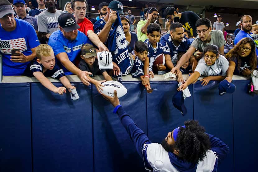 Dallas Cowboys running back Ezekiel Elliott (21) signs autographs for fans after the team's...