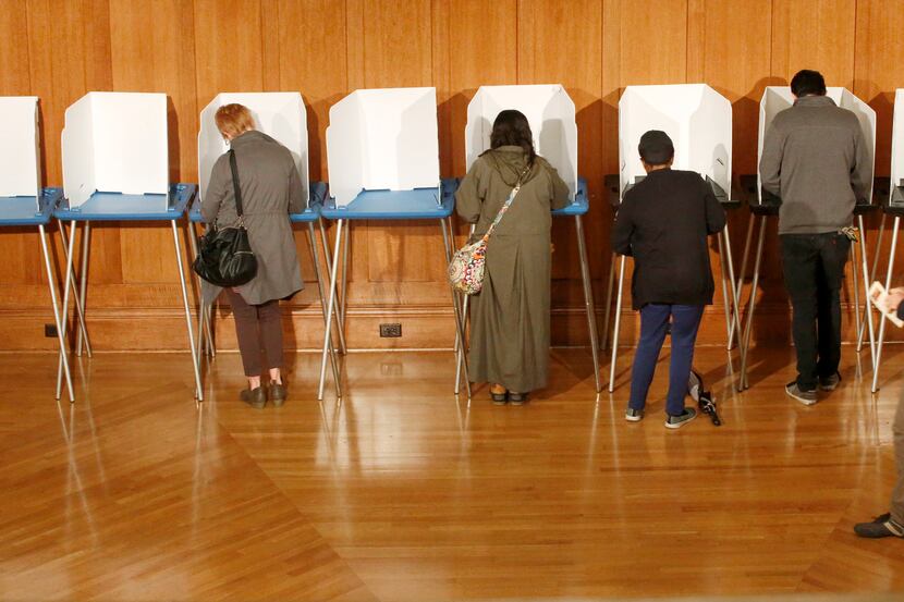 The first people in line before the polls opened Tuesday cast their votes at Grace United...