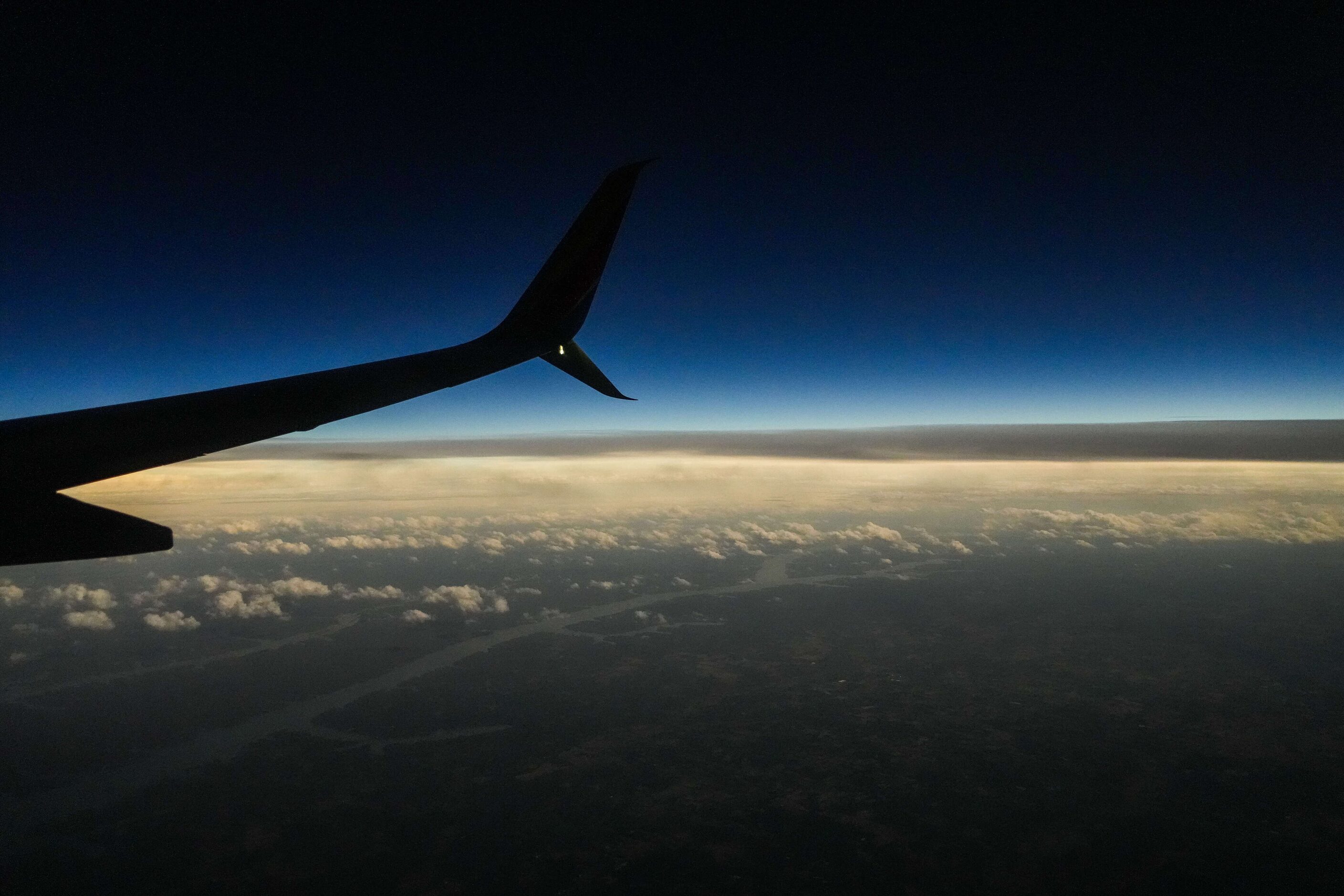 The colors of sunset stretch to the horizon during a total solar eclipse as seen from...