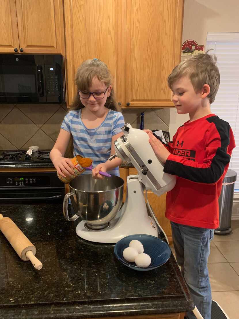 Lily Romito, 8, and Luca Romito, 6, prepare homemade dog biscuits to sell at Maggie's...