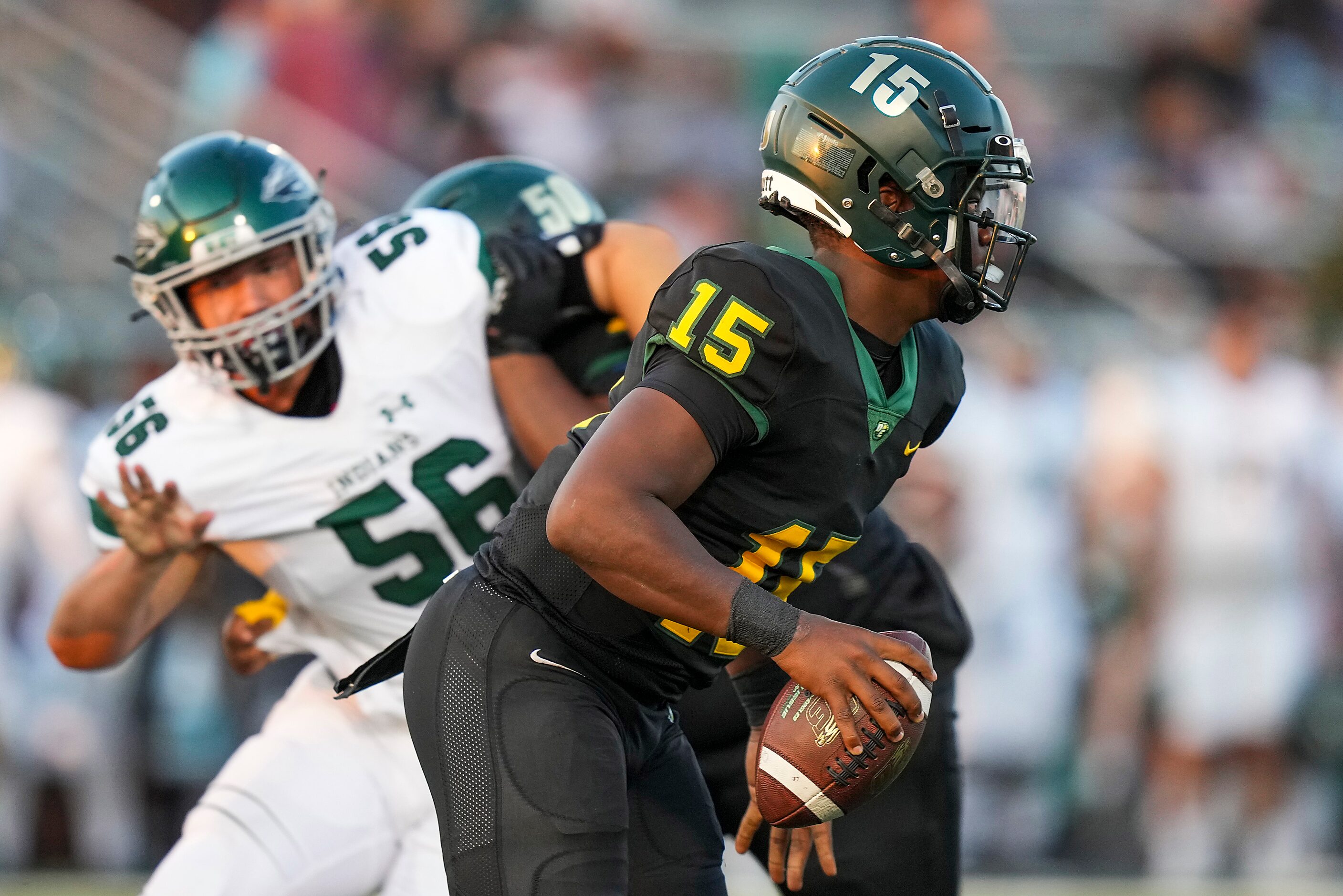 DeSoto quarterback Darius Bailey (15) scrambles away from Waxahachie defensive lineman Gavin...